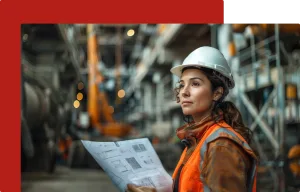 Female engineer wearing a hard hat and high-visibility vest, holding technical blueprints in an industrial setting, symbolizing comprehensive engineering services by Prism PSG, focused on delivering innovative, efficient, and tailored solutions.